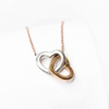 Collar de corazones chicos entrelazados.  Incluye cadena de 45cm con expansor para alargar o acortar la cadena.  Dije de oro combinado rosa/blanco y cadena de oro rosa 10 kilates.