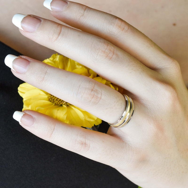 Argolla de Matrimonio Oro 10k ; En la mano de una modelo sosteniendo una flor color amarilla